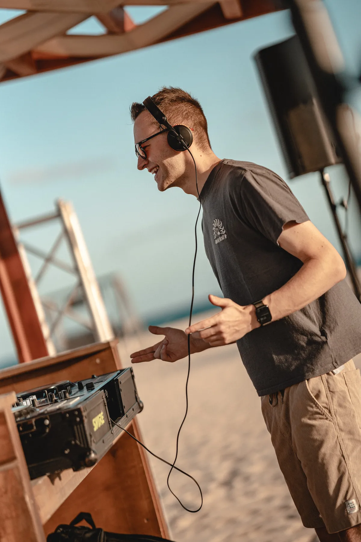 DJ Moritz Gräßler legt mit Kopfhörern an einer Strandbar auf den Kapverden auf