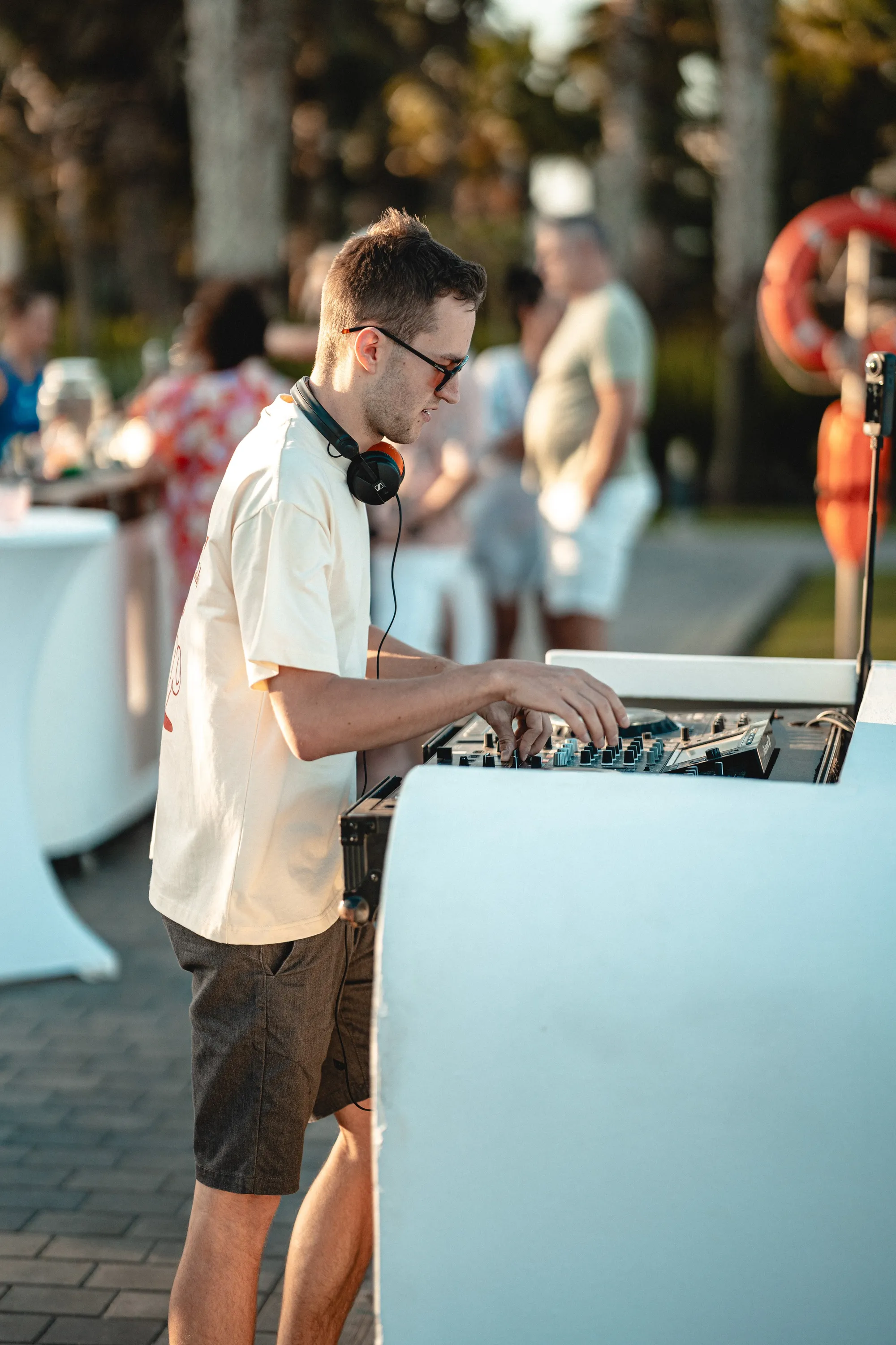 DJ Moritz am weißen Pult, Hochzeitsgäste stehen am Pool auf den Kapverden