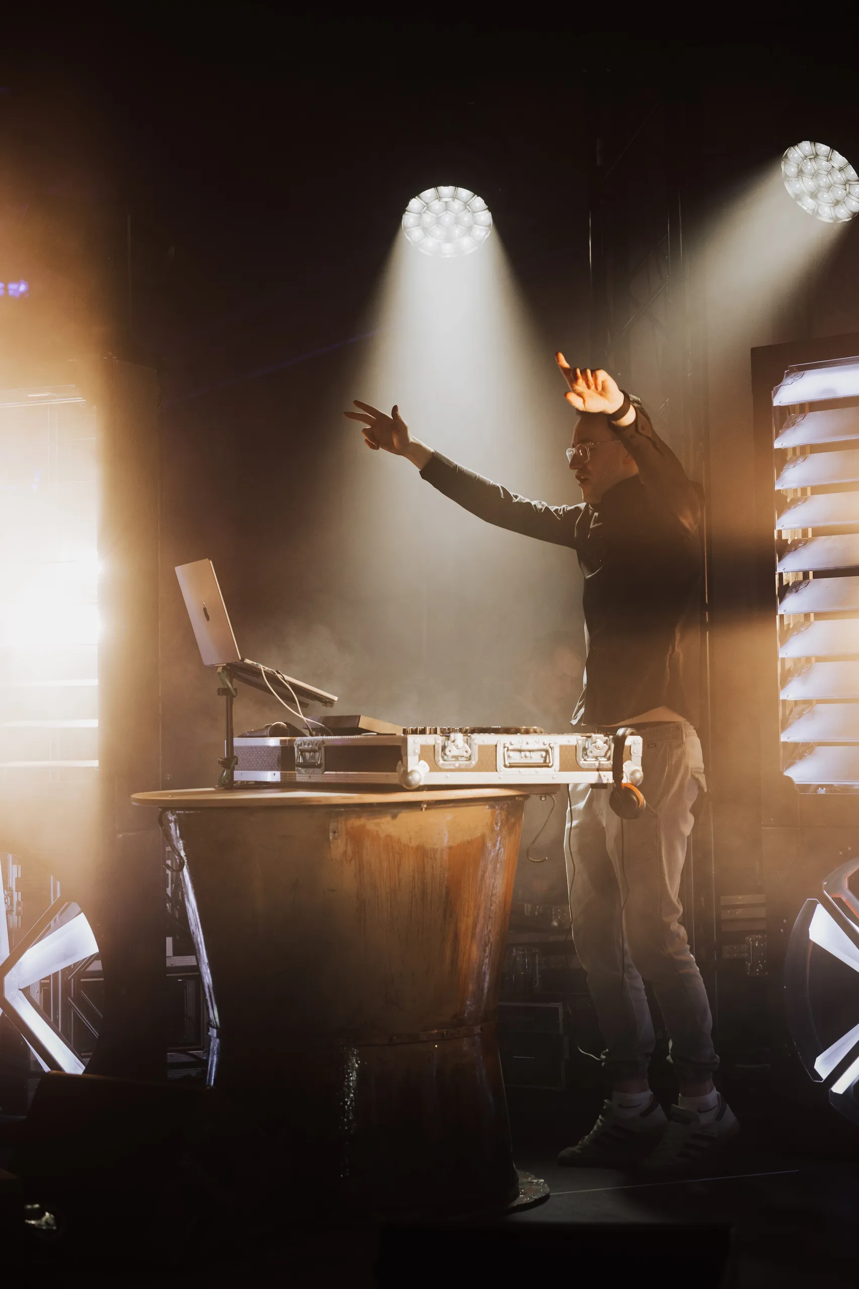 DJ Moritz auf einer Bühne im Gegenlicht weißer Scheinwerfer