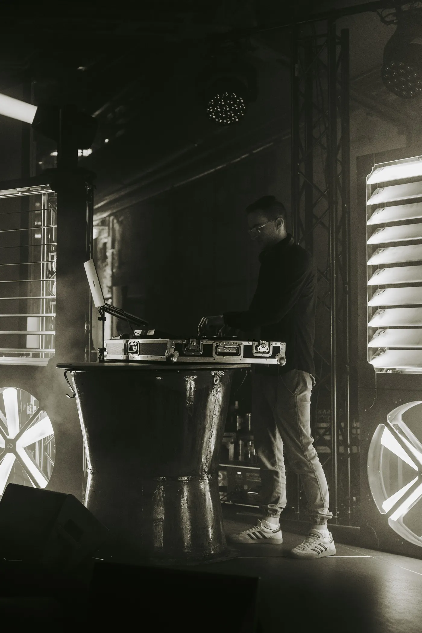DJ Moritz am Pult auf einer Bühne mit Lichttechnik, Schwarzweißfoto