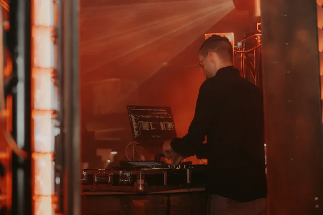 DJ Moritz am Pult im roten Licht