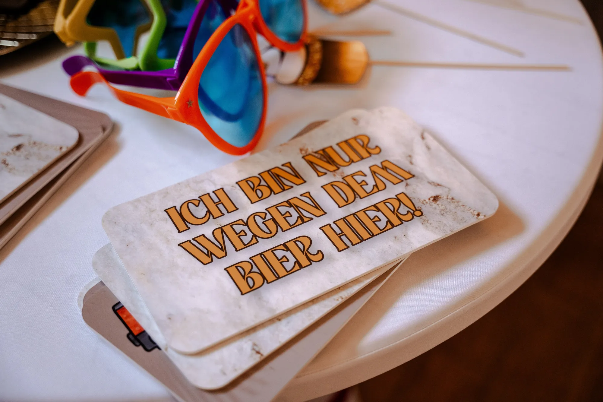 Fotobox-Requisiten auf einem Tisch: bunte Partybrillen und Schilder mit Sprüchen