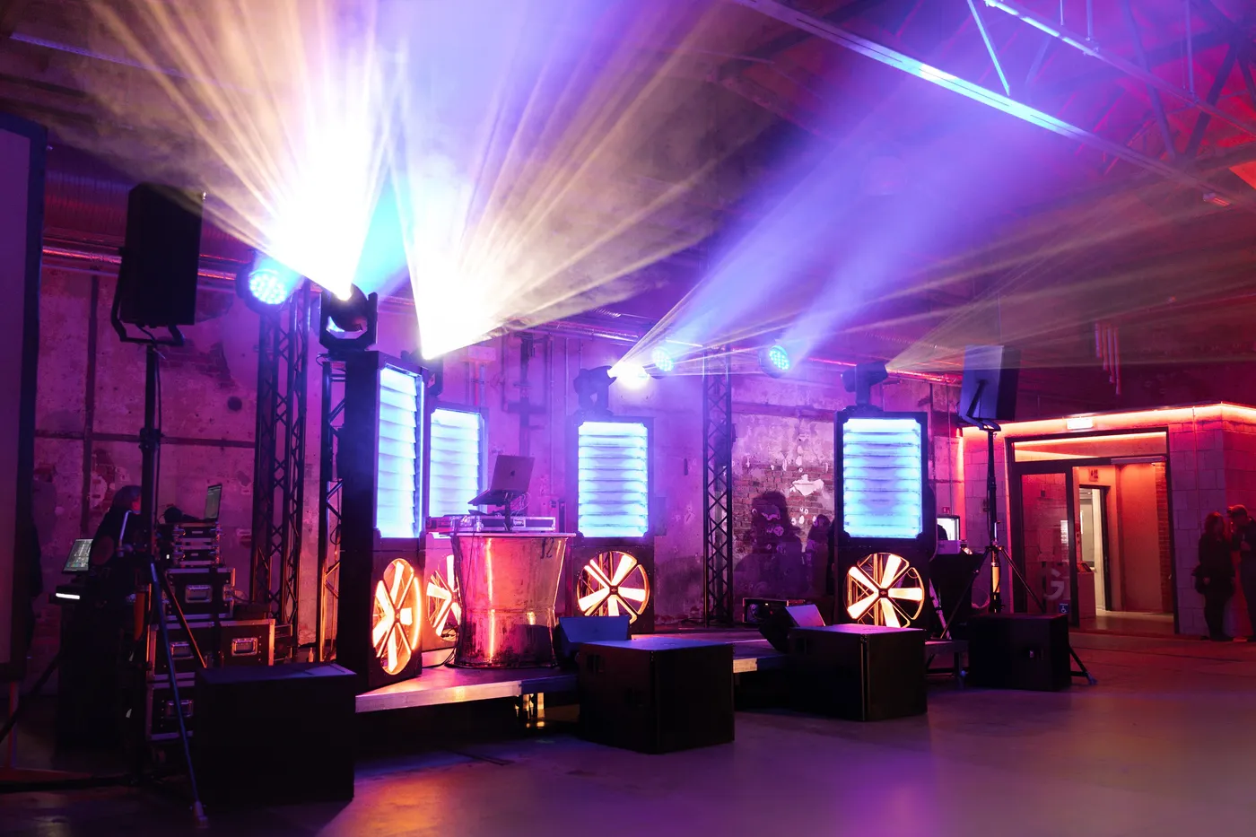 Lichtshow mit violetten Strahlern und Lichtsäulen auf der Bühne einer Firmenfeier